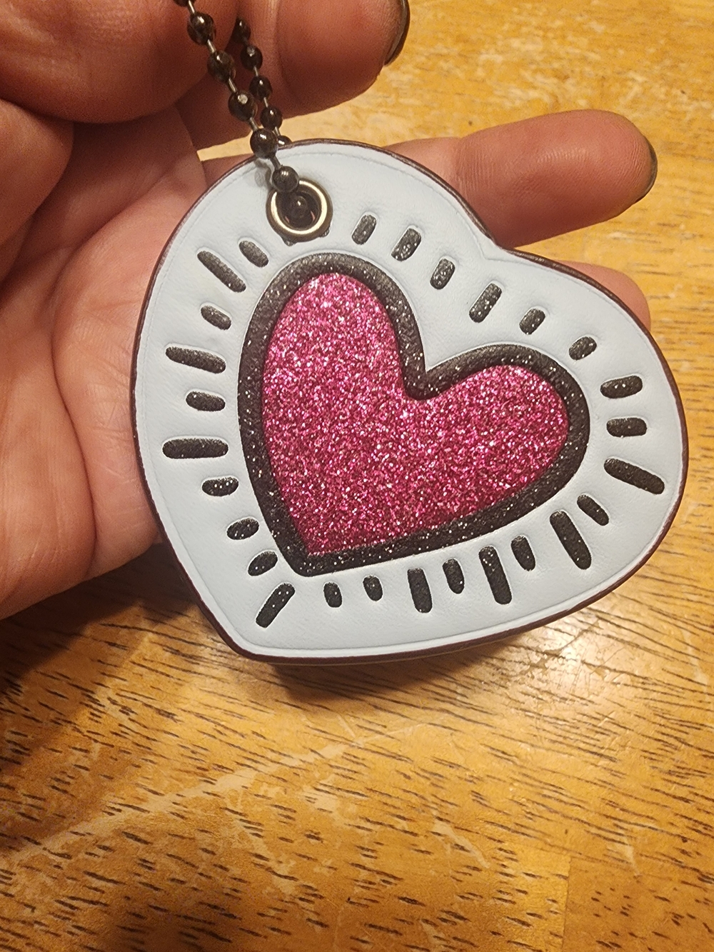 Coach x Keith Haring glitter heart bag charm with a pink sparkle center